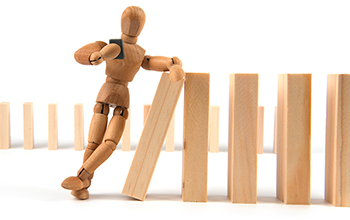 Wooden perspective man leaning on dominos