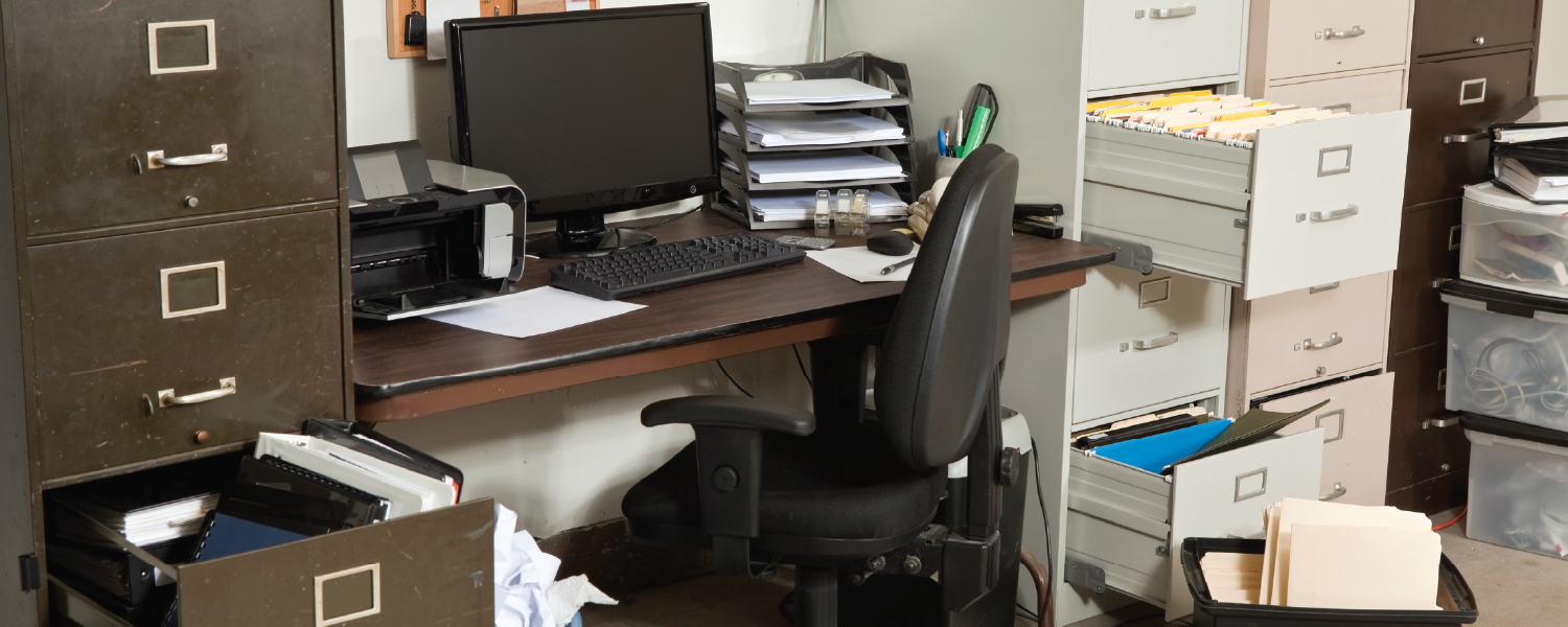 A disorganized office overflowing filing cabinets