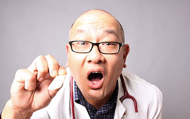 A doctor holding a tongue depressor