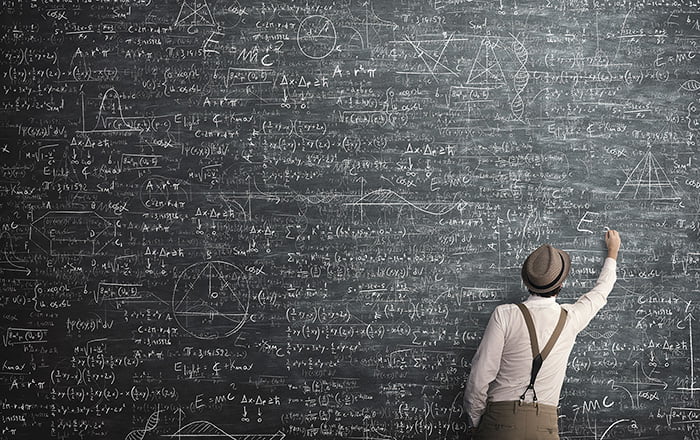 man calculating math equations on a chalk board