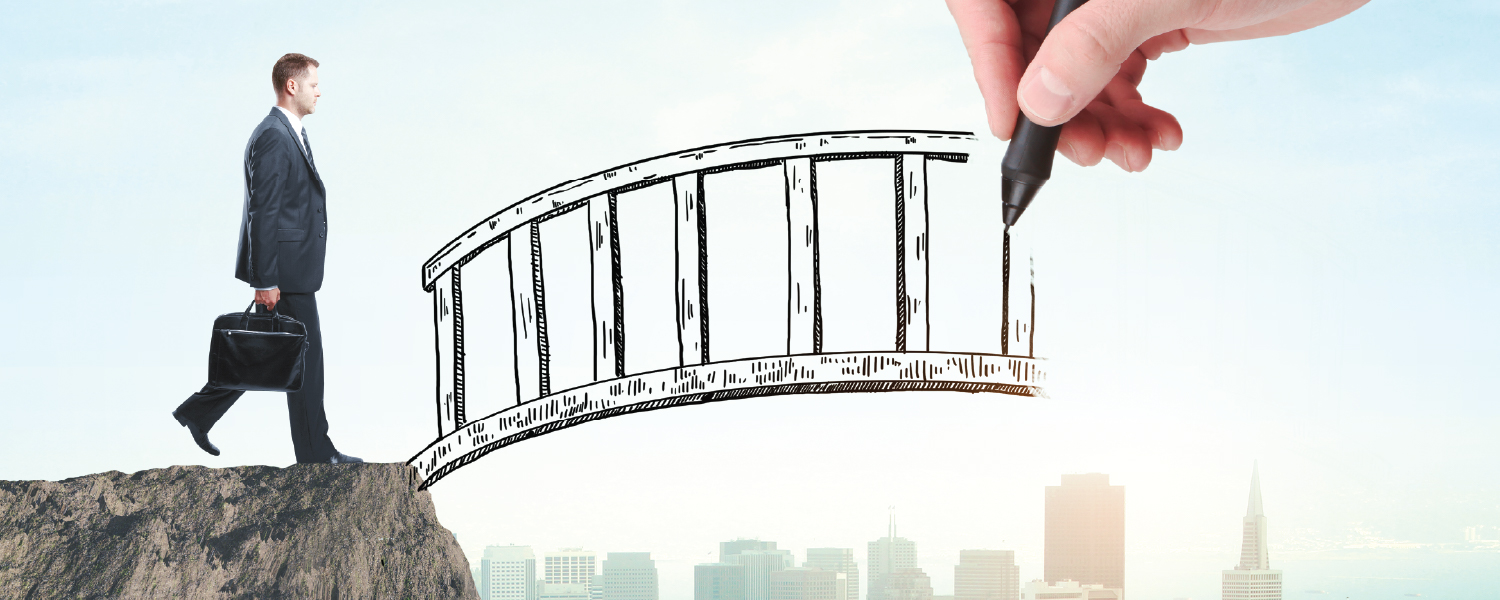 A businessman about to walk across an illustrated bridge being drawn by a hand