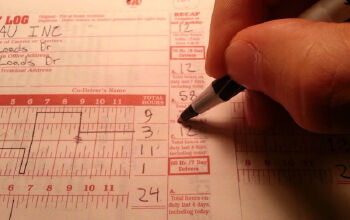 A driver completing their logbook