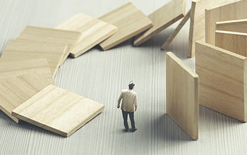 Falling walls threaten to round the circle and squish miniature man